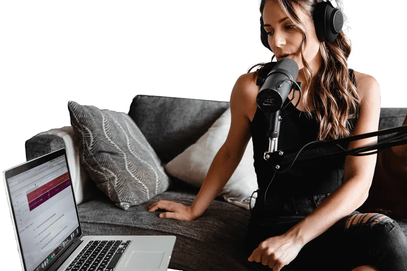 A podcaster recording at home with a microphone and laptop